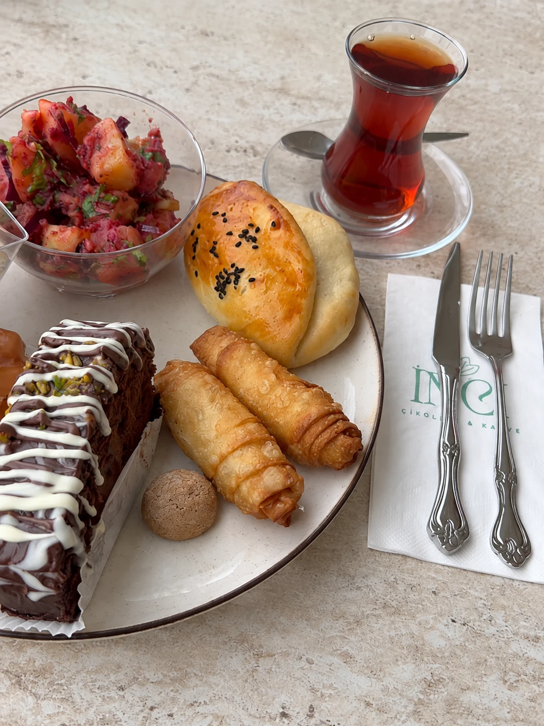 Çay eşliğinde börek, kek ve poğaçadan oluşan ikram tabağı